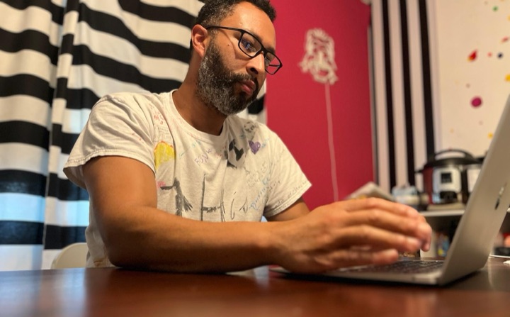 Nat Love writing at his laptop